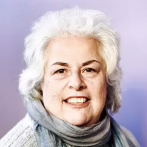 A smiling woman with white hair