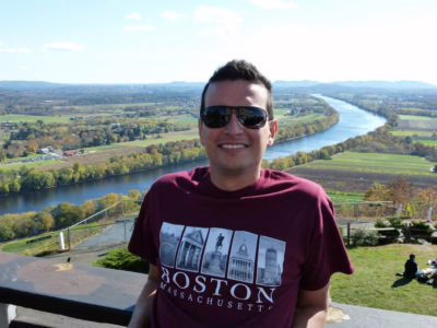 A student posing in front of a river.