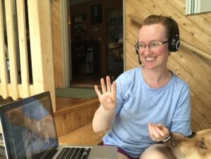 Woman holding up 4 fingers to online line class