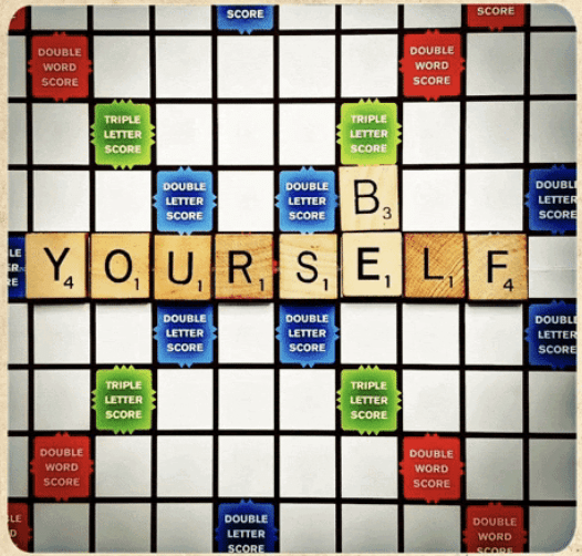 A scrabble game board with Be Yourself spelled out.