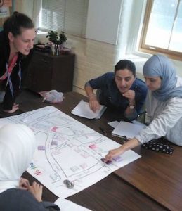 Instructor teaching directions to students using a map.