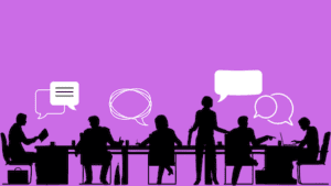 Silhouette of people working and talking at a conference table.