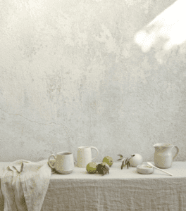 A monochrome eggshell colored image of a table with coffee mugs and table linens.