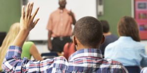 Student raising their hand to speak in class.