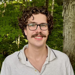 A man with curly hair and glasses.