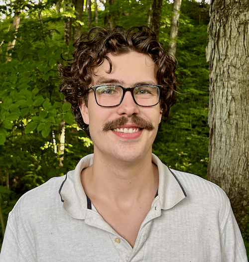 A man with curly hair and glasses.