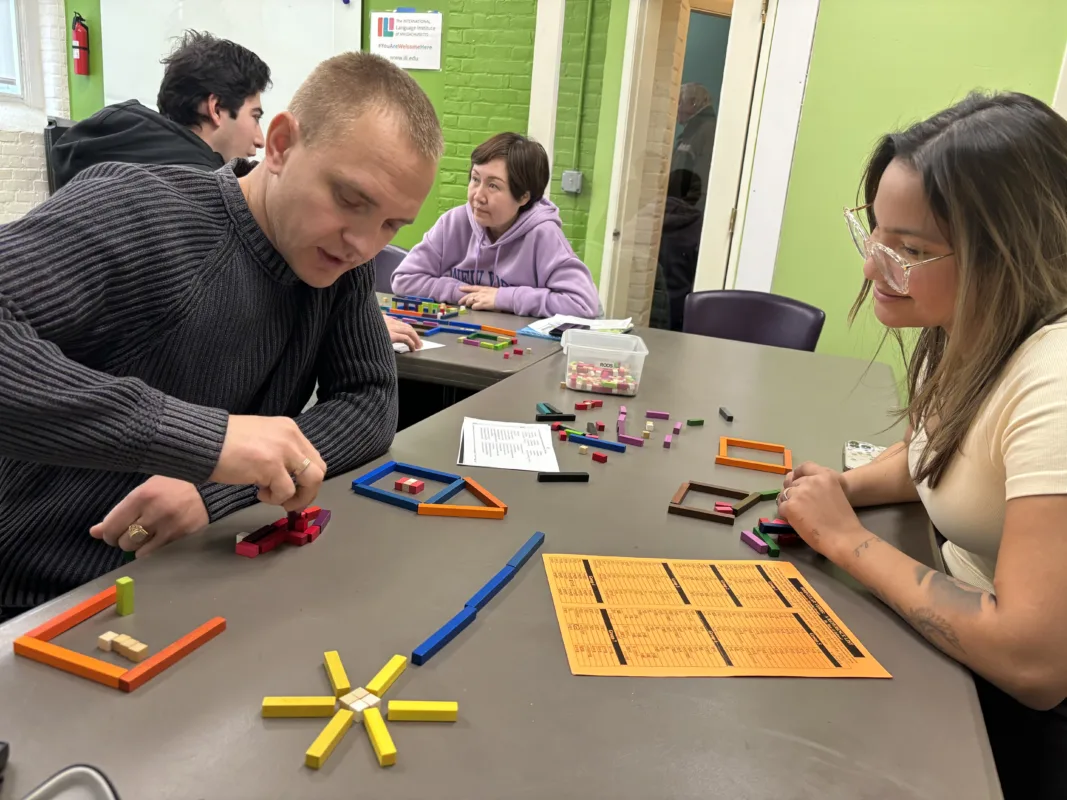 students working in pair using blocks to practice specific grammar