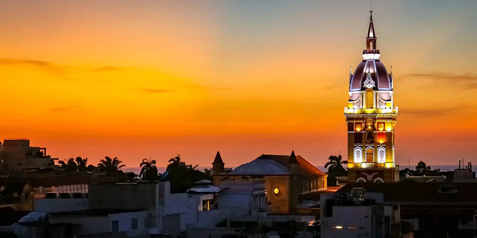 Sunset over Cartagena cathedral against orange sky.
