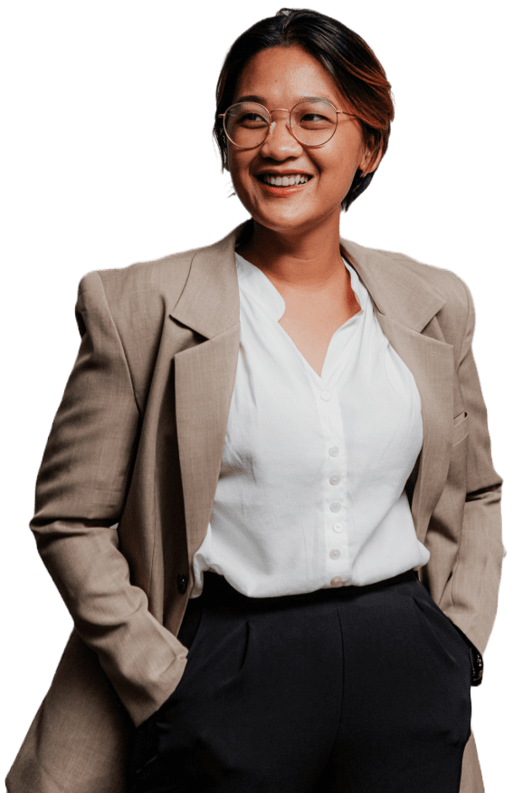 A professional woman wearing a suit and glasses with a cheerful smile on her face.