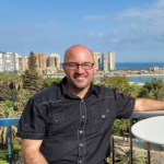 Man sitting at a balcony table.