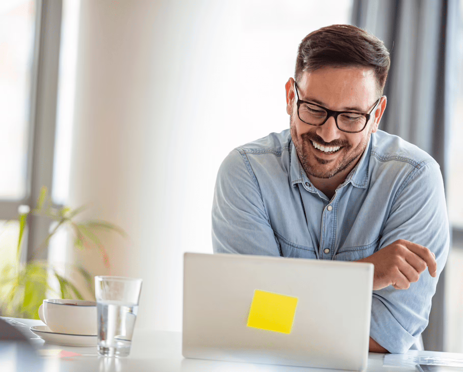 Smiling man engaged in online exchange.
