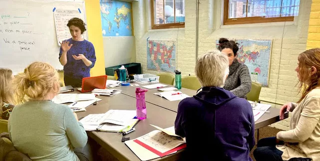 Jennie Coletta, teaching Italian to 5 students sitting around a table at the International Language Institute in Northampton, MA.