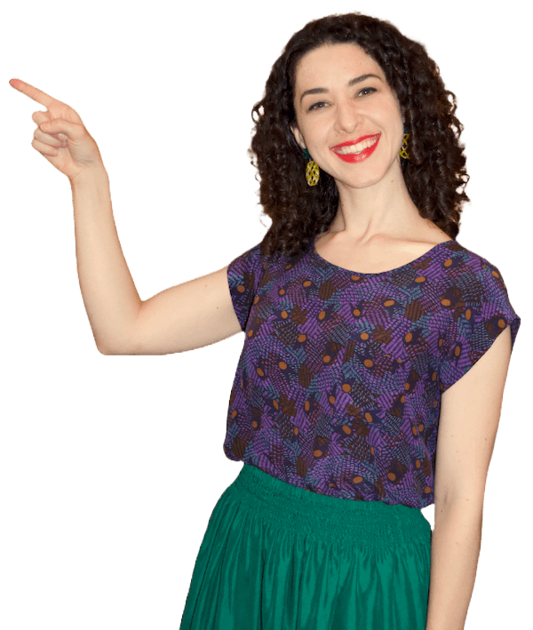A woman in a purple top and green skirt, pointing.