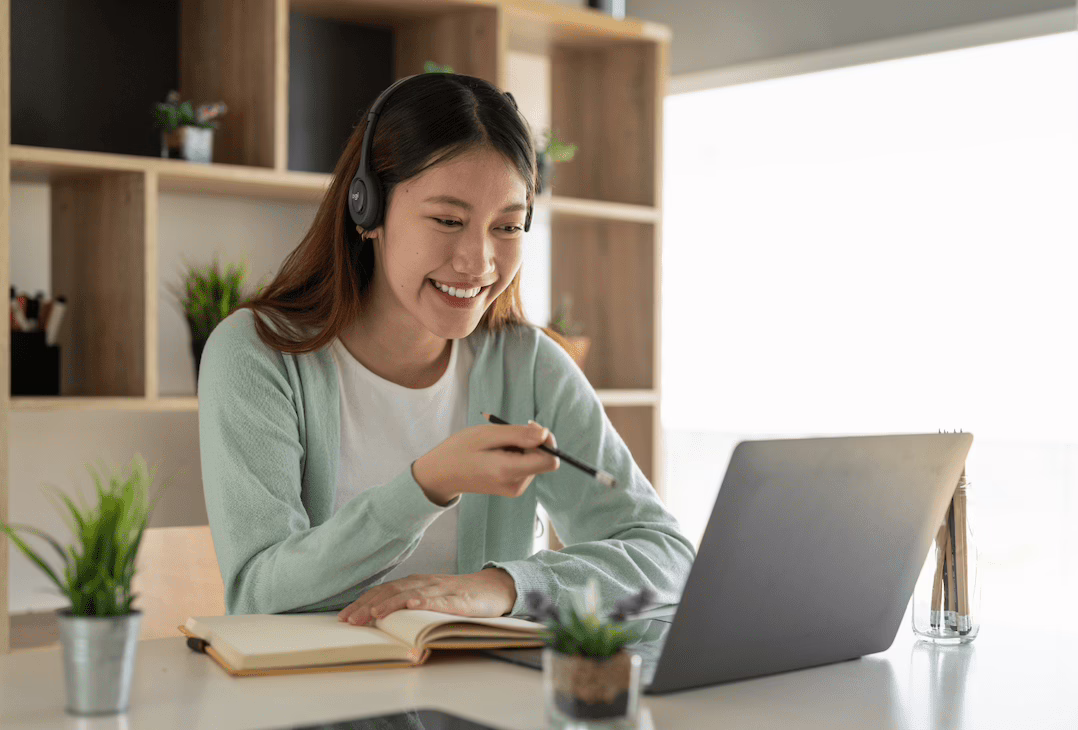 A smiling woman interacting online with her classmates.