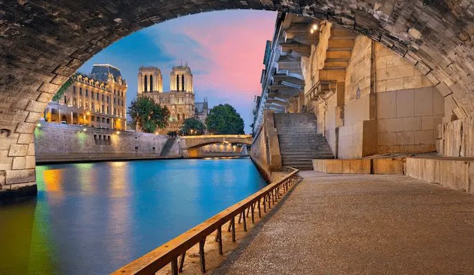 An image of the Notre-Dame de Paris Cathedral and the riverside of Seine river in Paris, France.