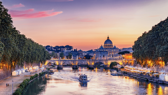 A view up the Tiber River of Rome, Italy with St. Peter's Cathedral in the distance.