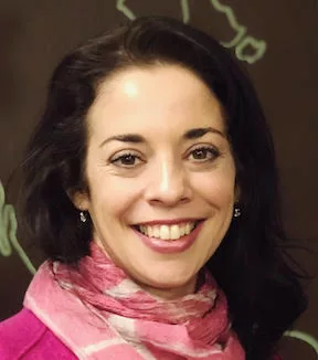 A smiling woman with dark hair and a pink scarf