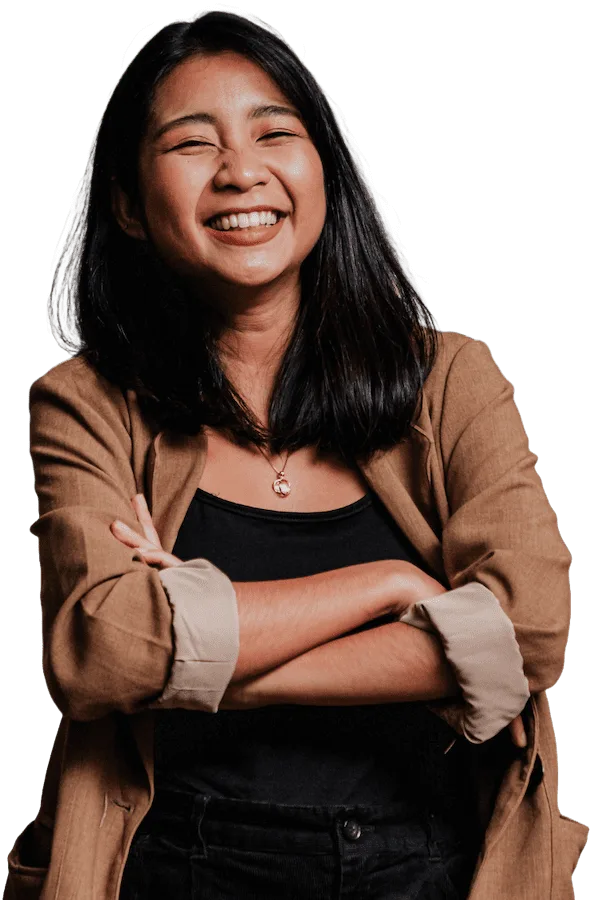 A confident woman with a warm smile, standing tall with her arms crossed.