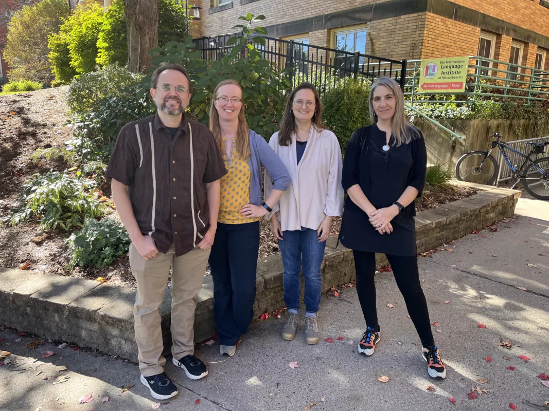 Four ILI English teachers in front of the school on a sunny day.