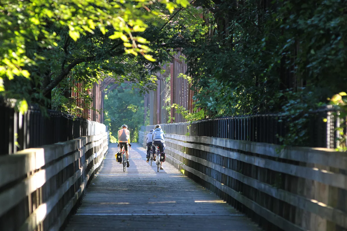 People riding their bikes on the bike path bridge over the Connecticut River.