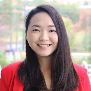 A young woman with long dark hair wearing red sweater