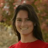 A young woman smiling wearing a red shirt