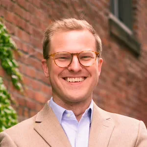 Smiling man with glasses and blond hair