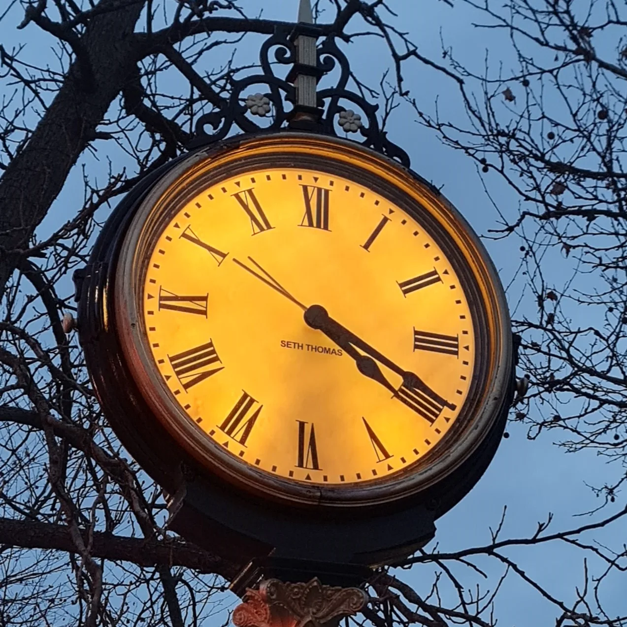 A large outside clock with hands pointing to 4:20pm