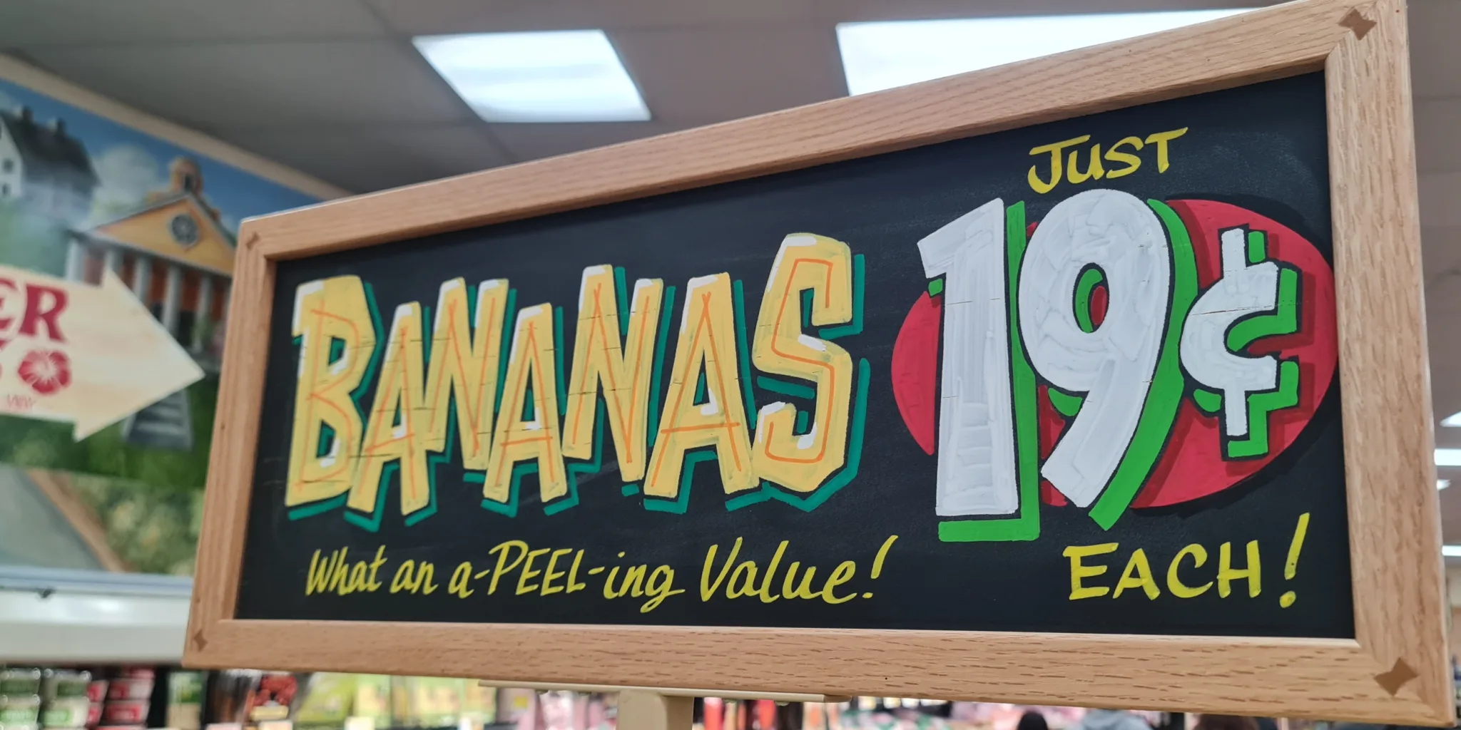 A chalkboard sign that says Bananas .19 cents each.