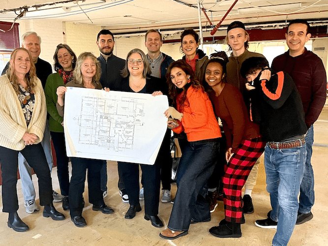 A group of people holding building plans.