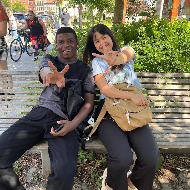 Two people enjoying each other's company on a park bench.