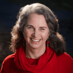 A woman wearing a red shirt smiling.