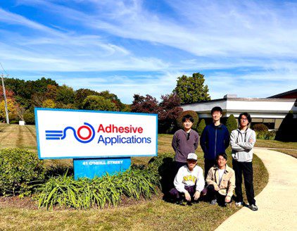 A group of international students from Japan standing in front of a factory after a visit.