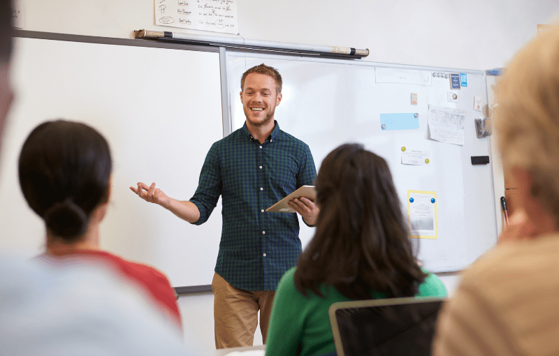 A man standing in front of a group of people in a classroom teaching.