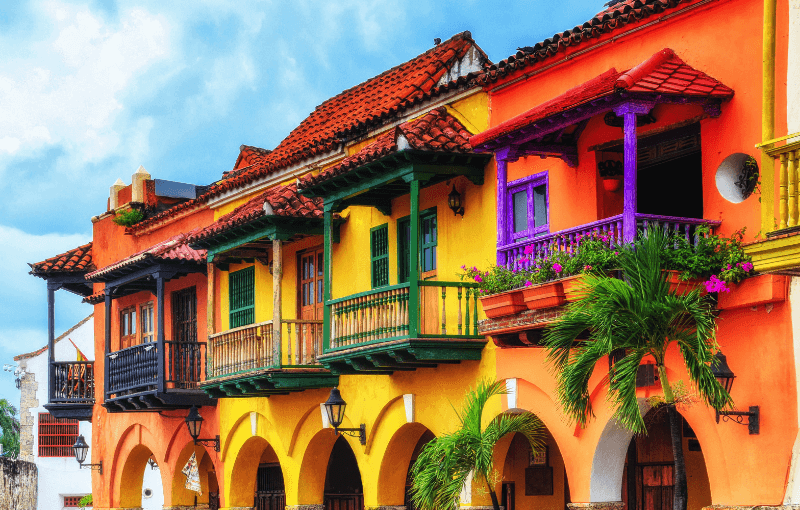 Vibrant buildings in Cartagena, Colombia, showcasing a blend of colors and architectural styles under a clear blue sky.