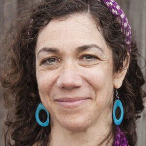 Head shot of a woman with blue earrings