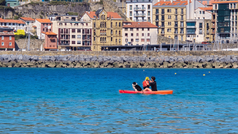 A person with a dog on a kayak.