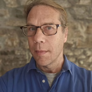 A man with glasses and a blue shirt