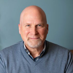 a man smiling as he looks at the camera