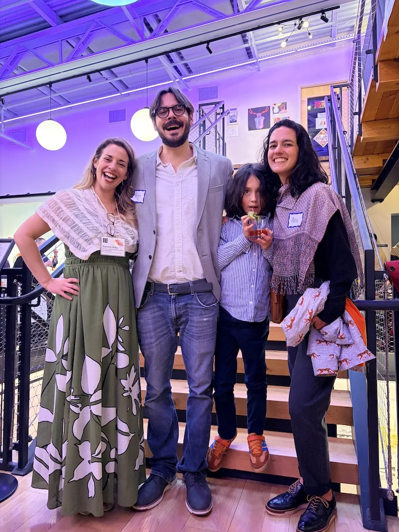 Three adults and a child smiling.