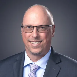 Smiling man with glasses.